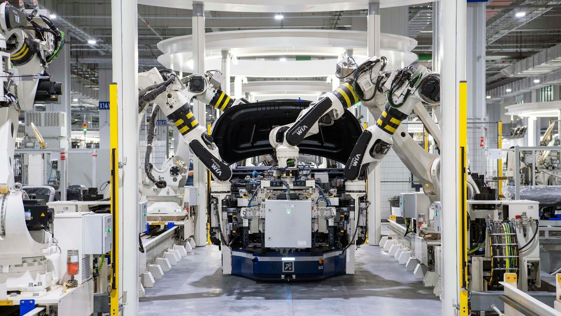 High-tech robots assembling a car in a modern factory setting, showcasing automation.