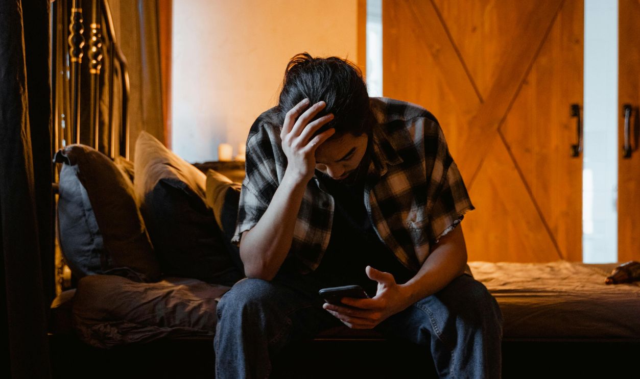 Tired Man Sitting on the Bed