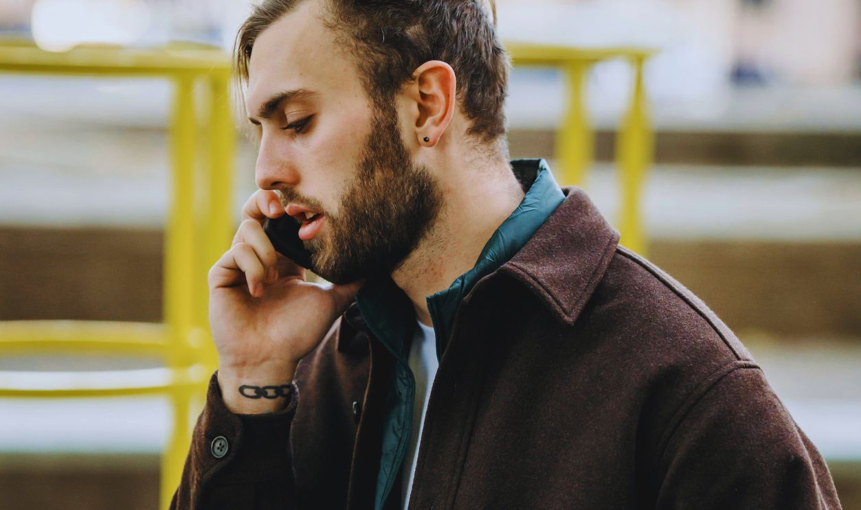 Pensive man talking on smartphone on street