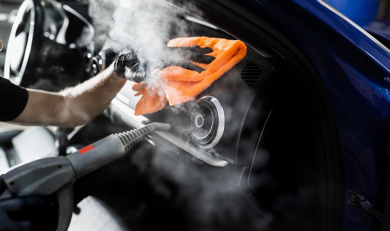 Steam cleaning of car air system. Worker in auto cleaning service clean car inside. Car interior detailing