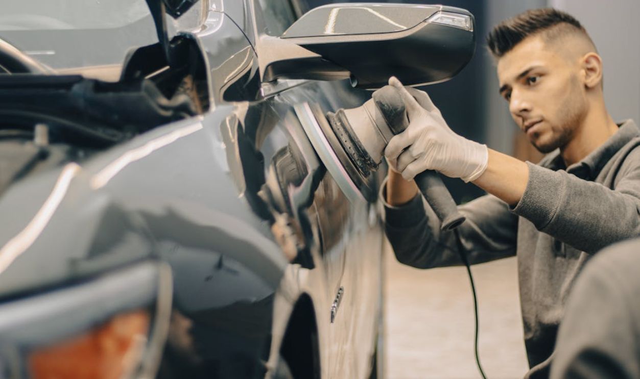 Man Polishing Car with Device