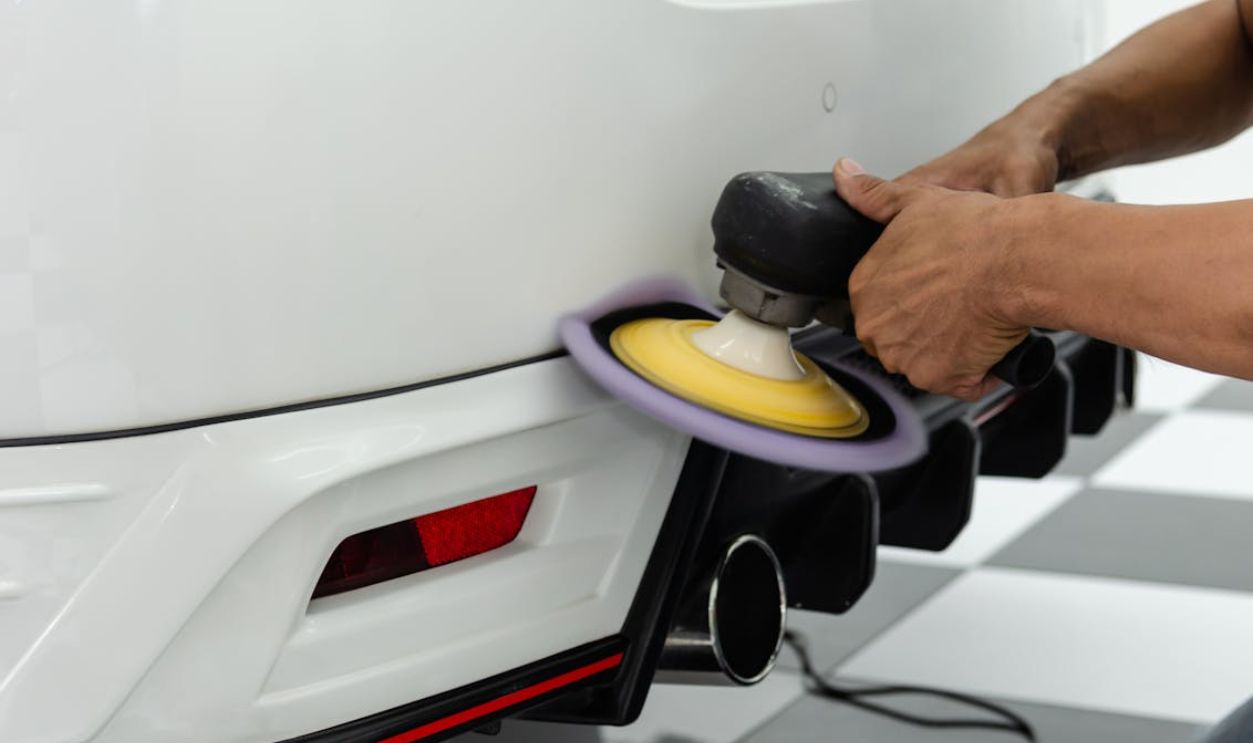 Person Polishing the Back of the White Car