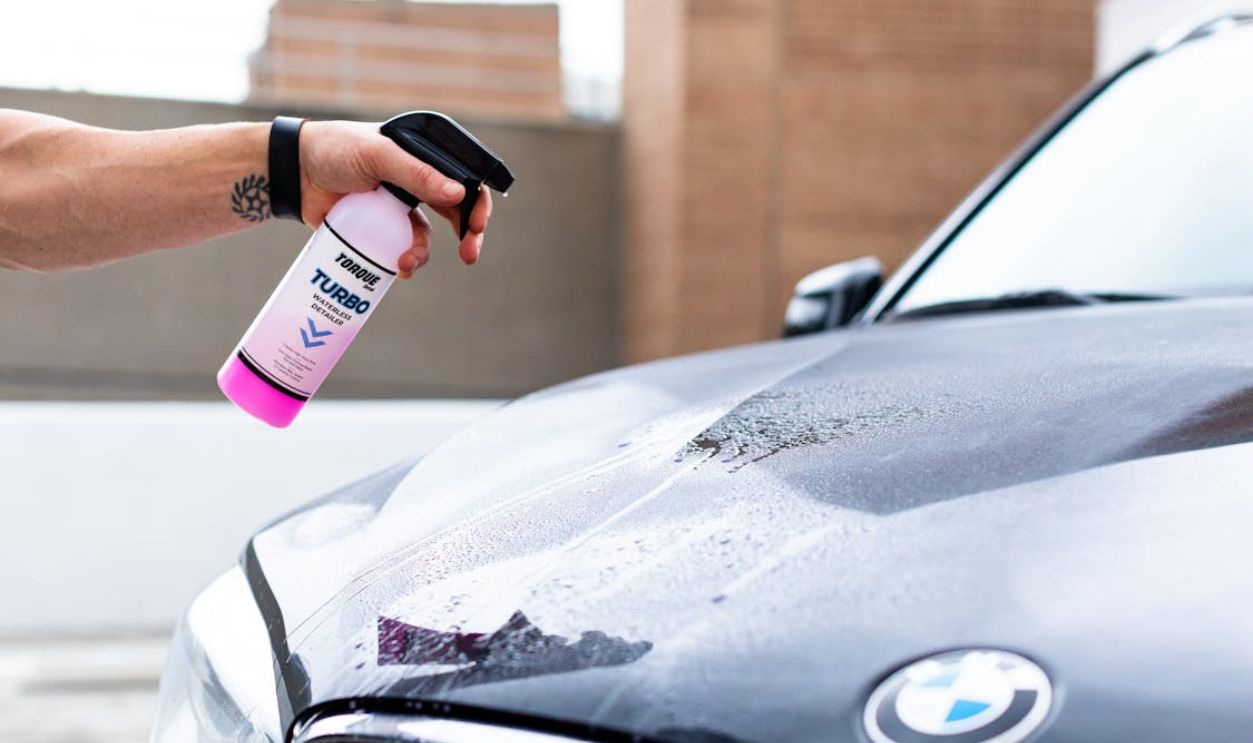 A Person Spraying the Hood of a Car