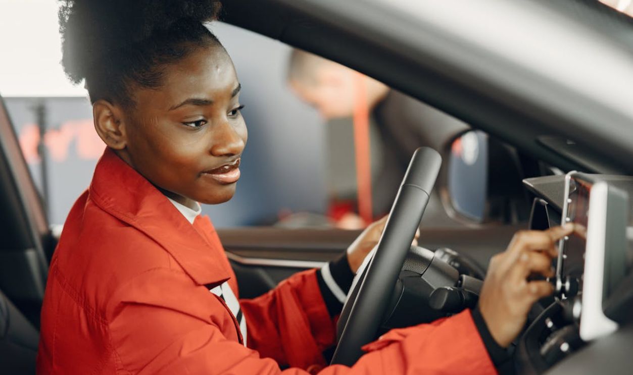 Man in Red Coat Touching the Screen of the Monitor Inside the Car
