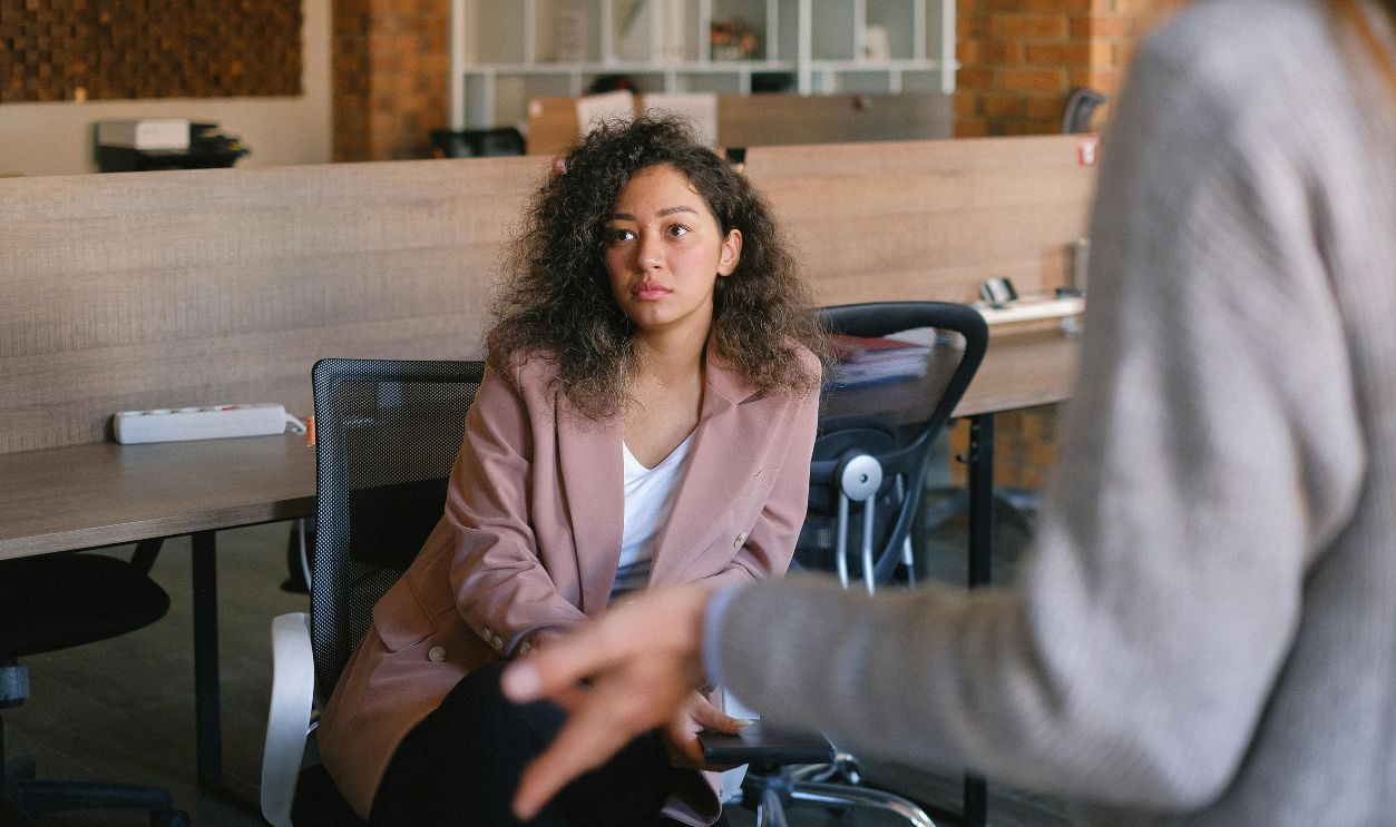 Serious woman listening to colleague in office