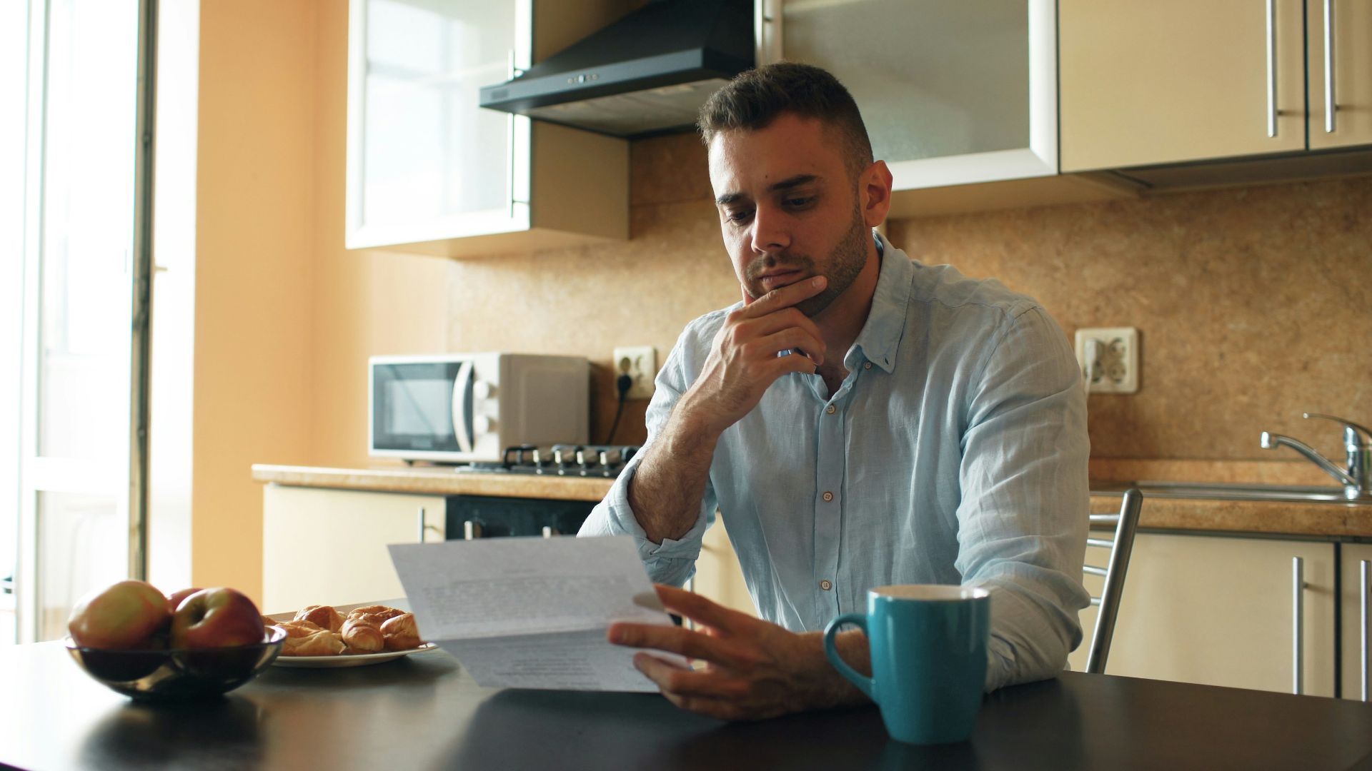Man reading a document in a kitchen