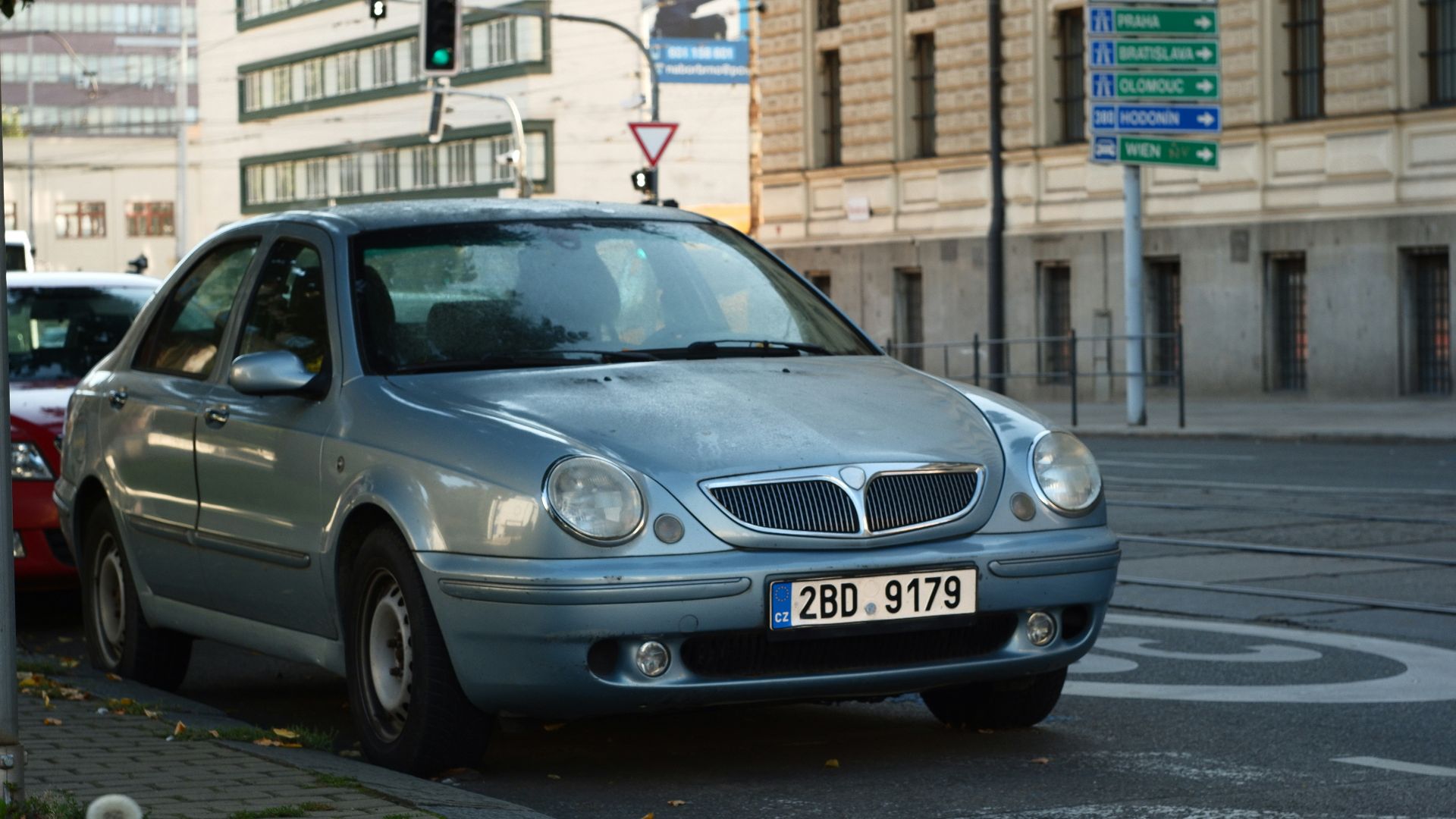 A light blue sedan parked on a city street.