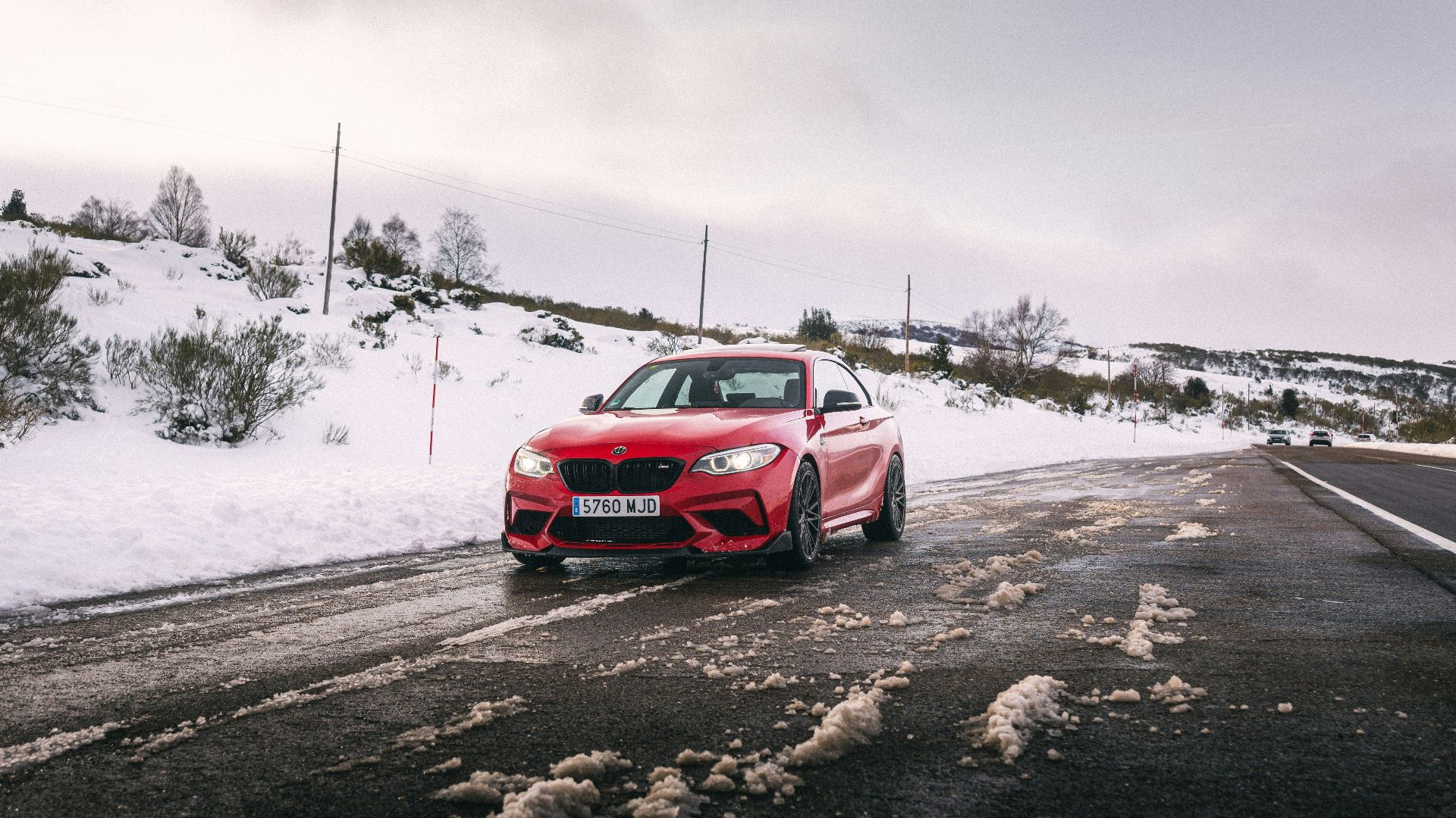 Red car driving on a snowy road