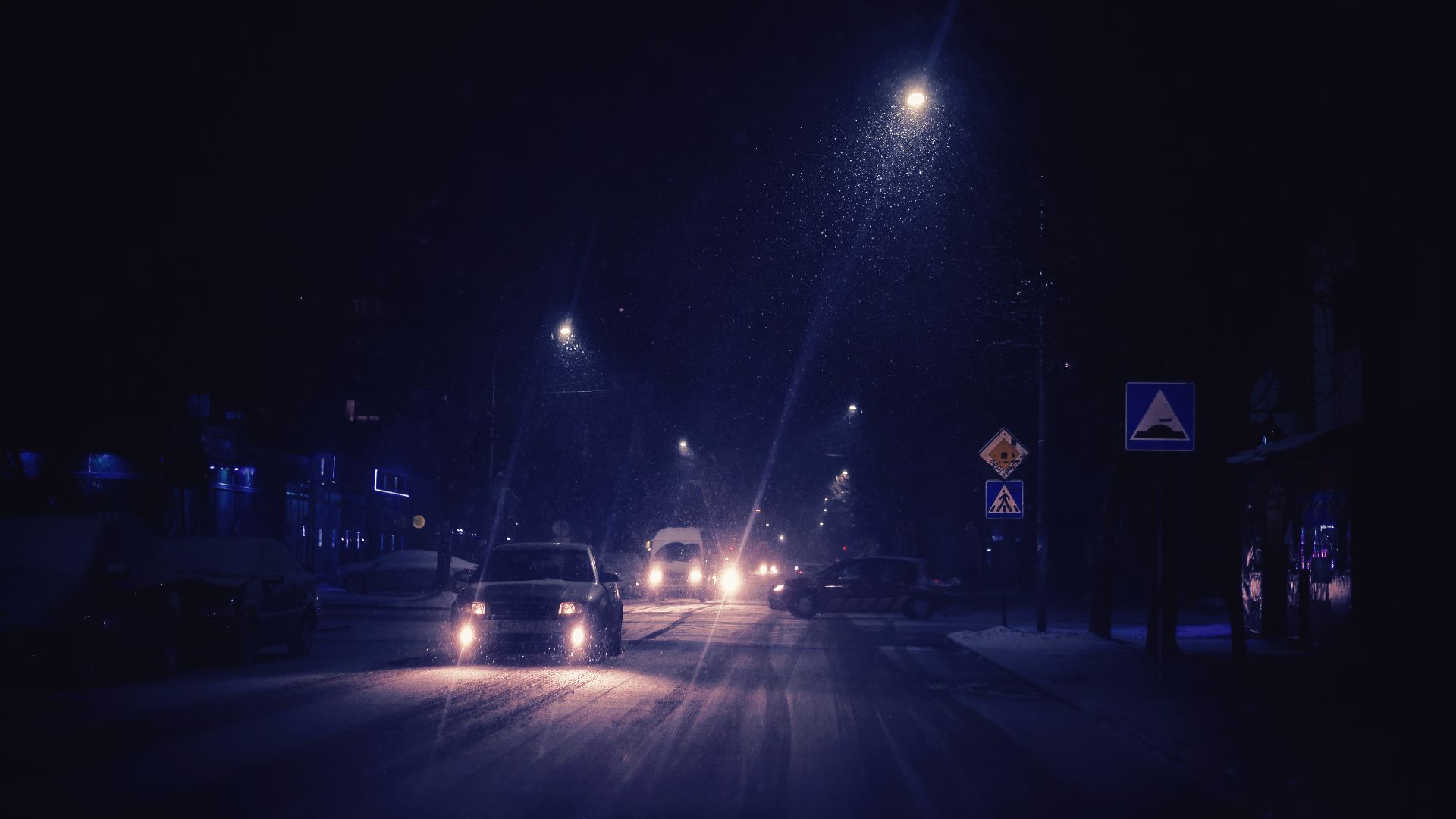 Snow has fallen in the city, a difficult situation on the street, the cars slowly pass with great caution, the night scene.
