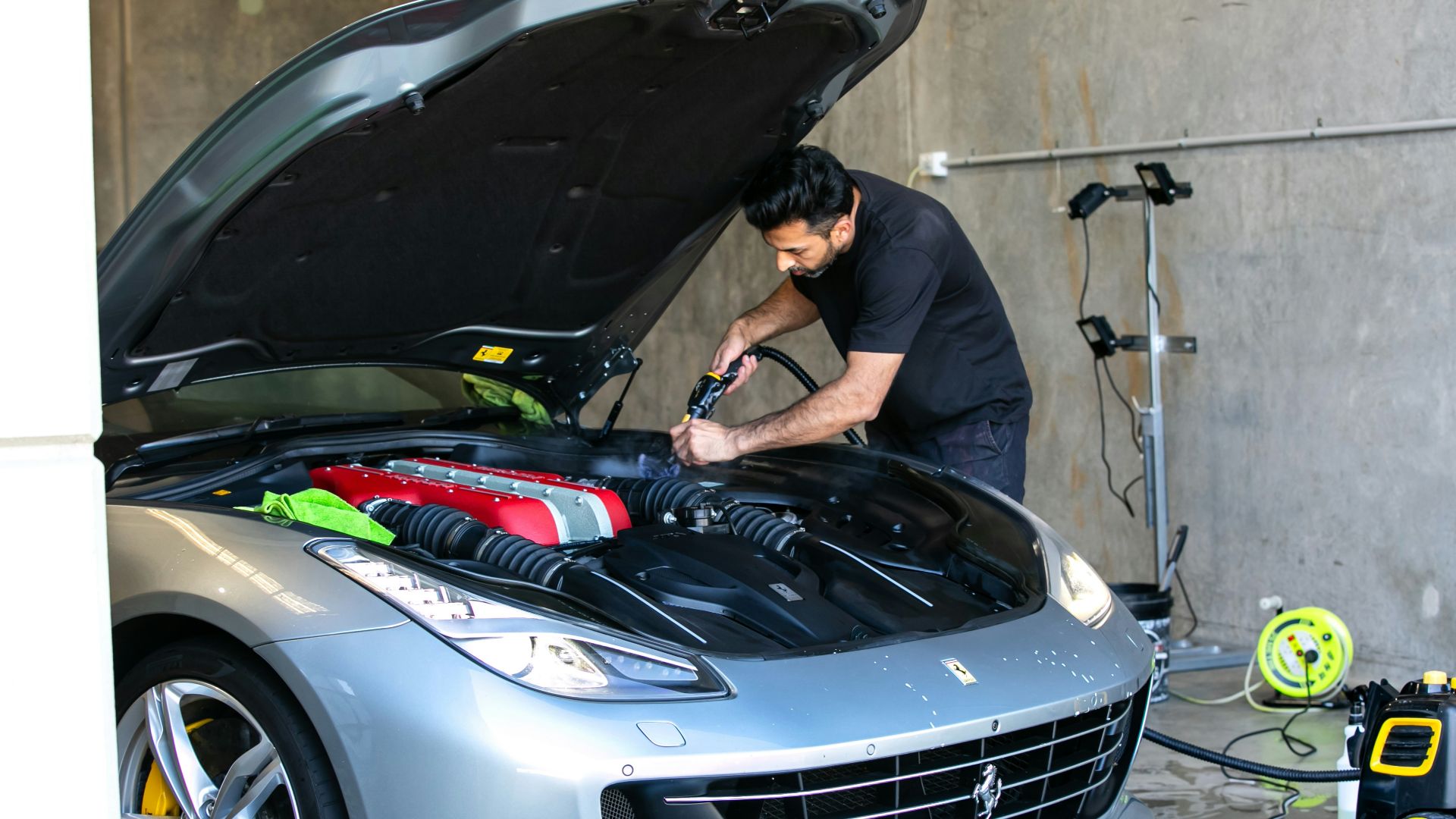 A mechanic is working on a ferrari car.