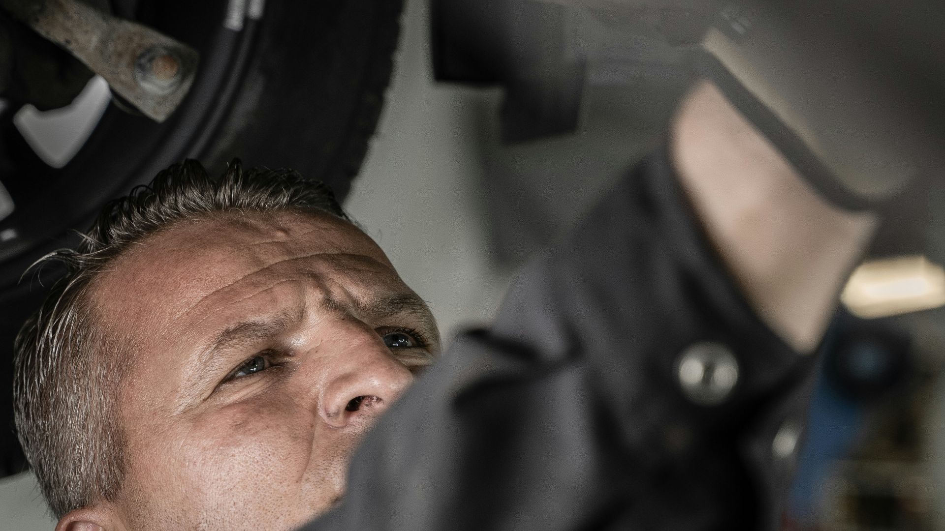 a man working on a car under a vehicle