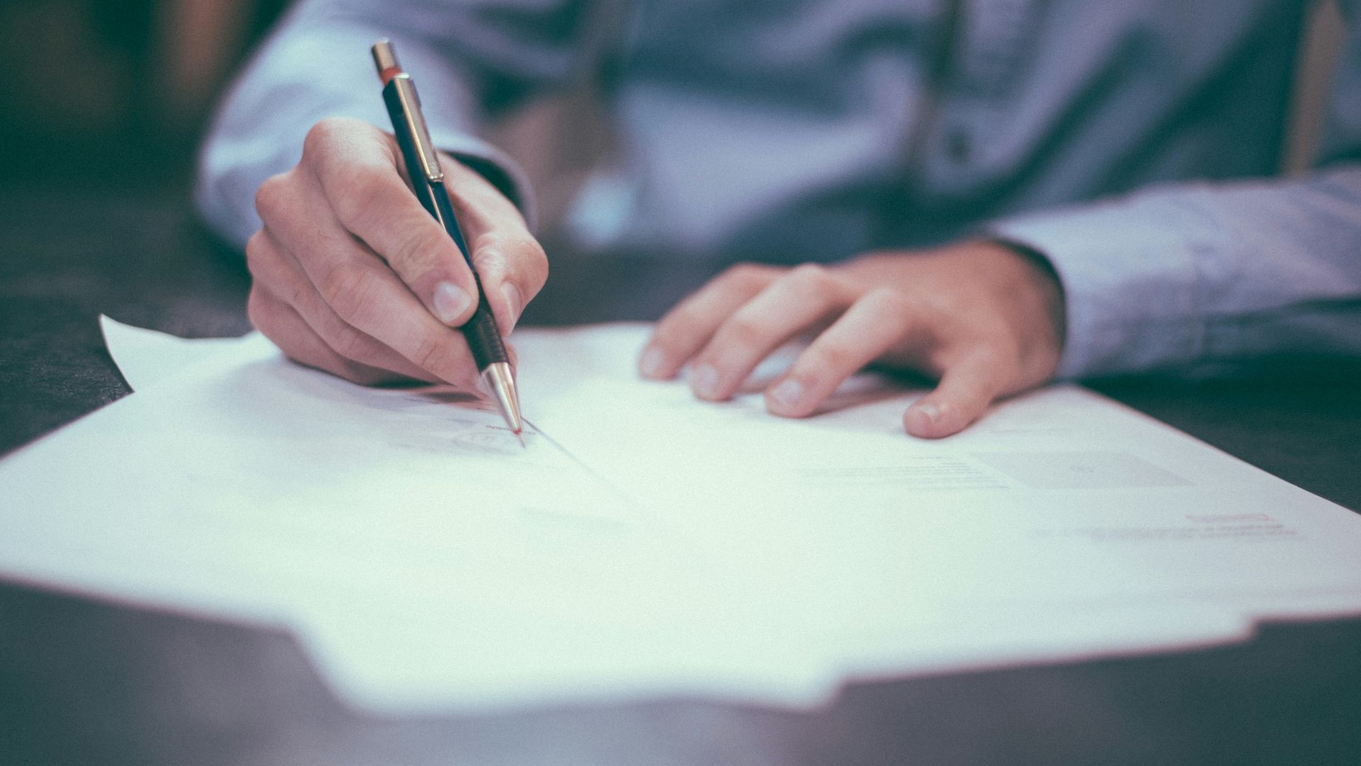 man writing on paper