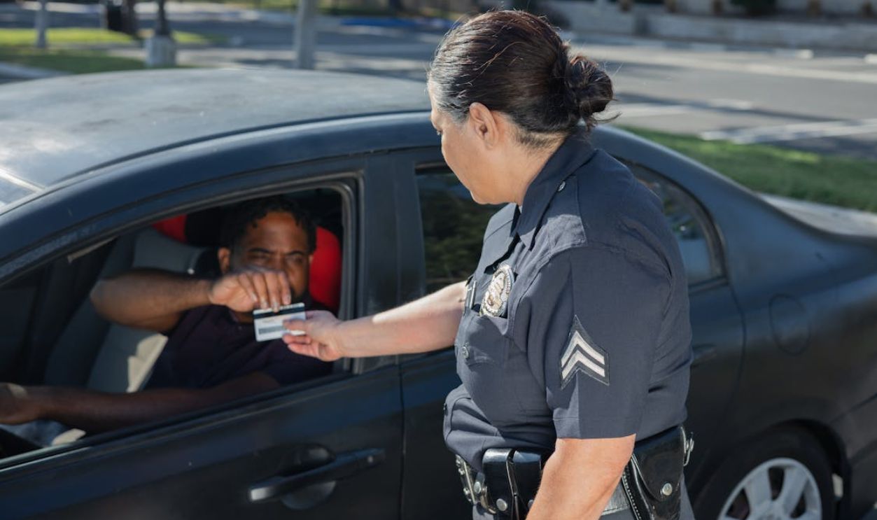 Man Giving His Driver's License to the Policewoman