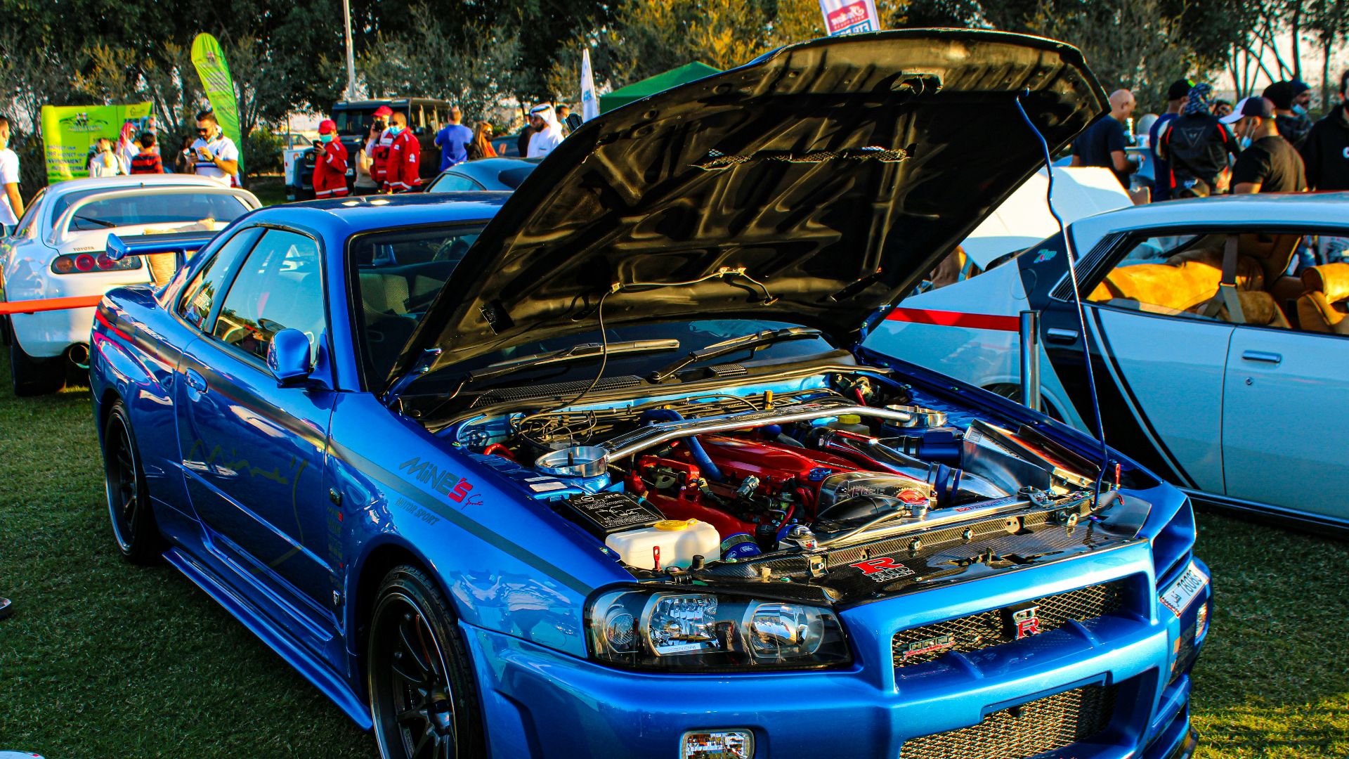 blue chevrolet camaro on green grass field during daytime