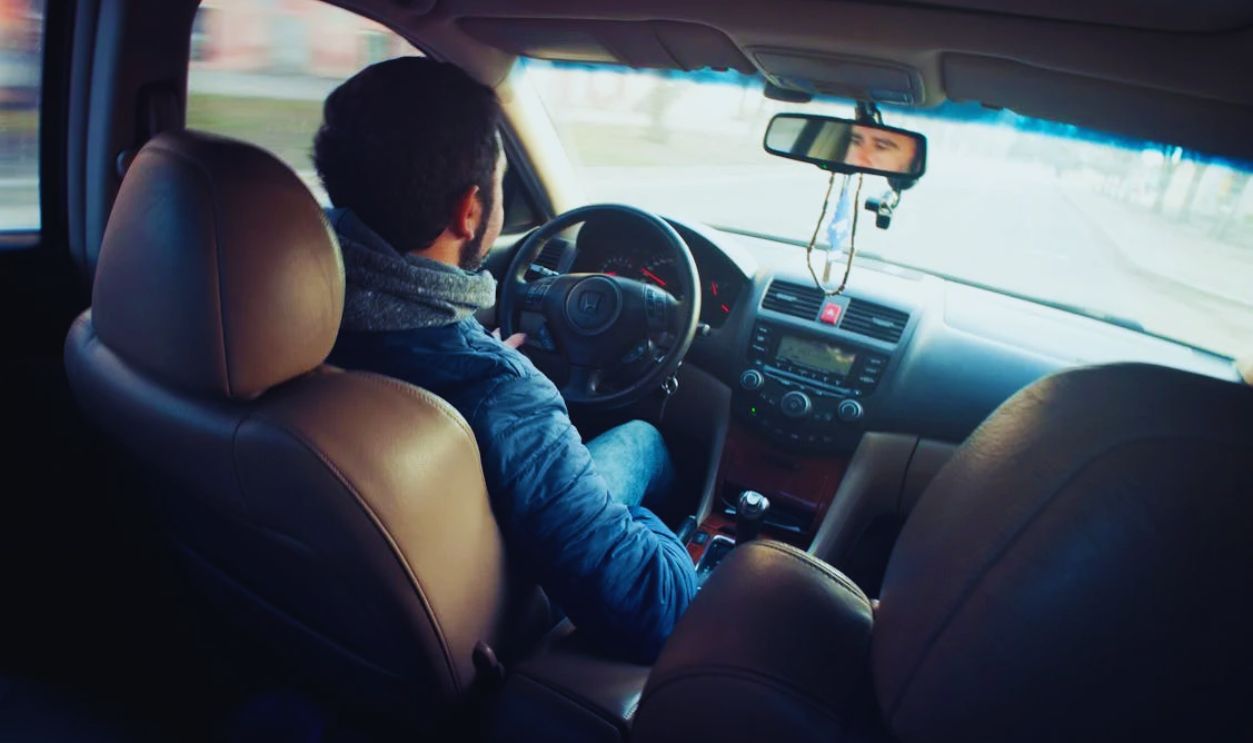 Man Wearing Blue Jacket Sitting Inside Car While Driving