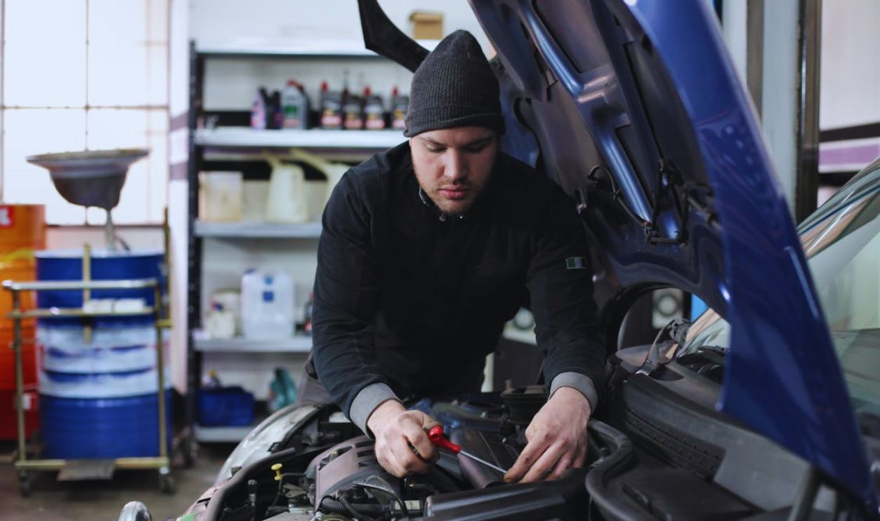 Man in Black Jacket and Black Knit Cap Standing Near Vehicle