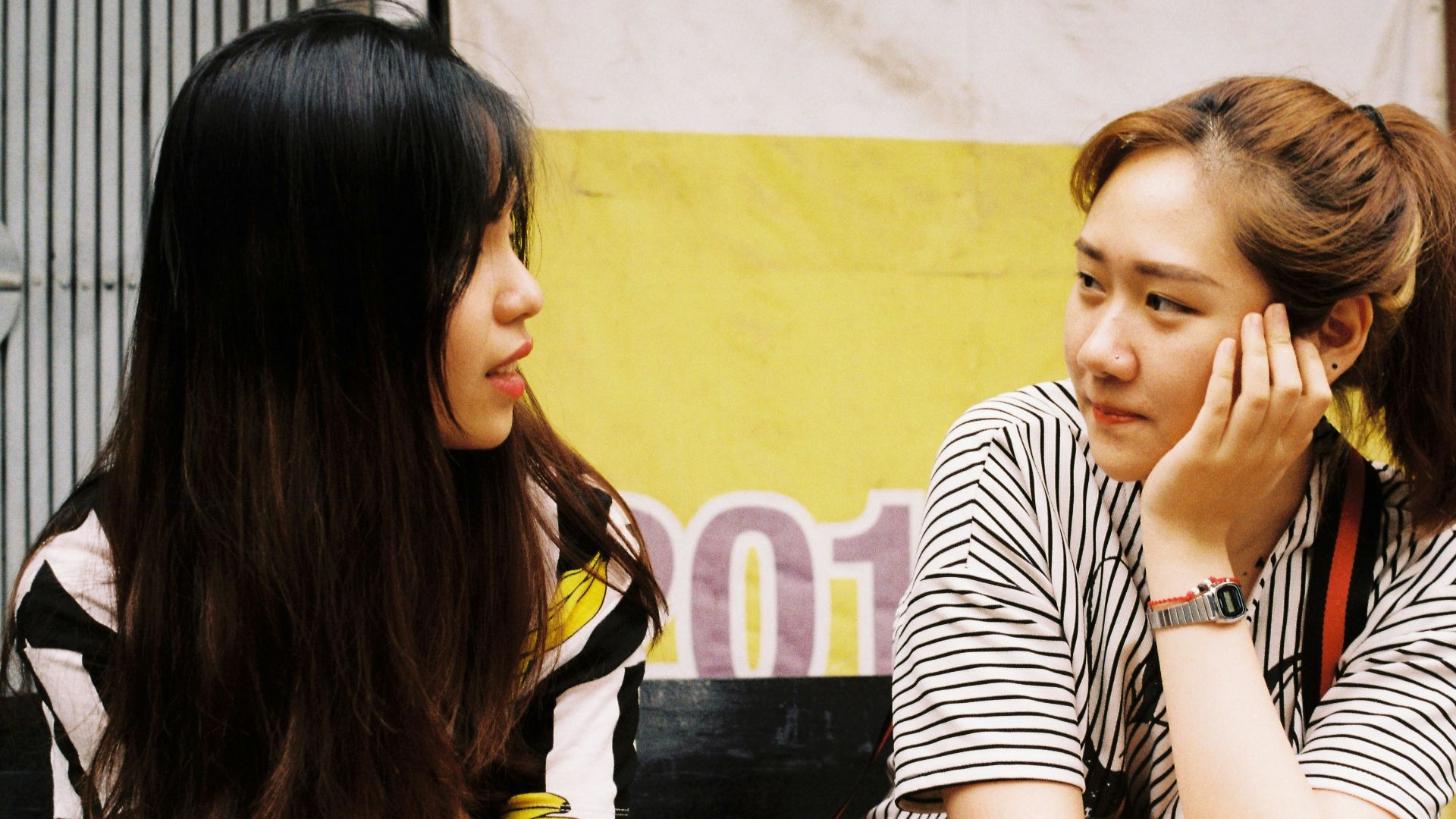 woman in white-and-black striped tops looking each other