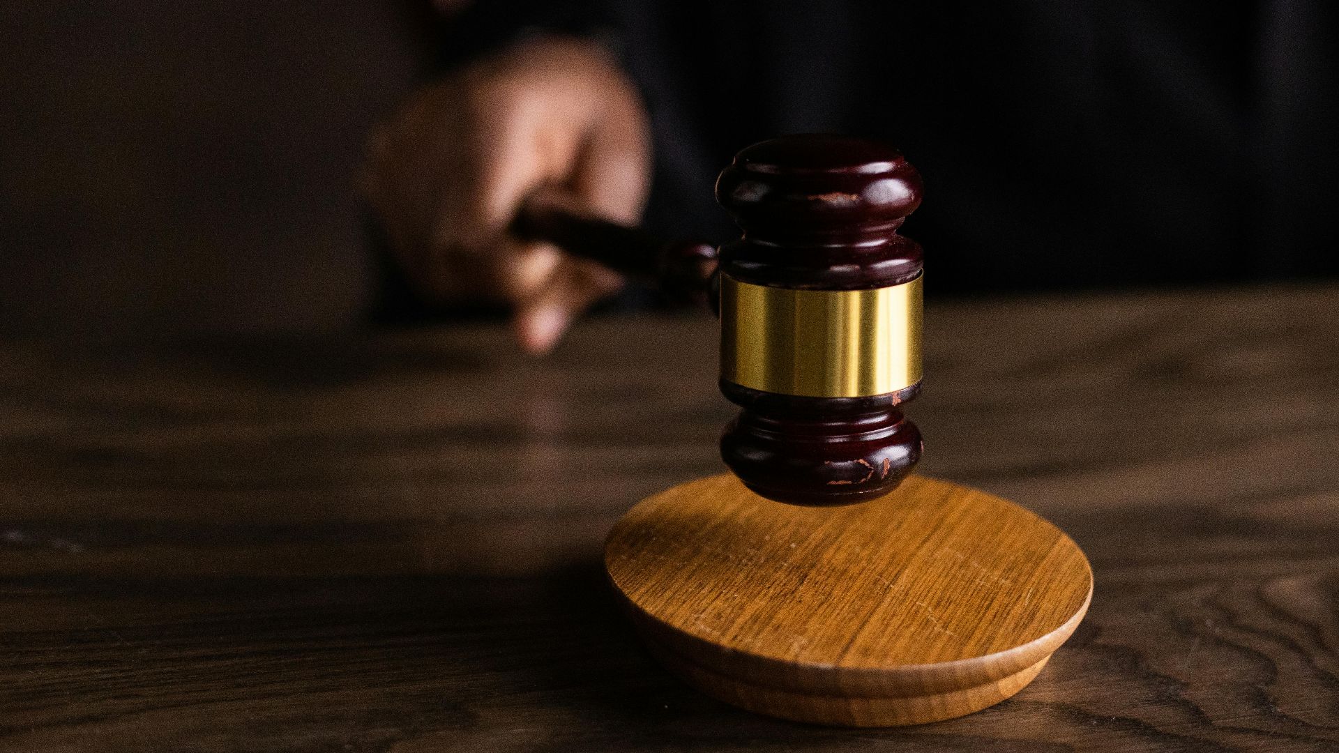A gavel striking a sound block, symbolizing justice and legal authority in a courtroom setting.