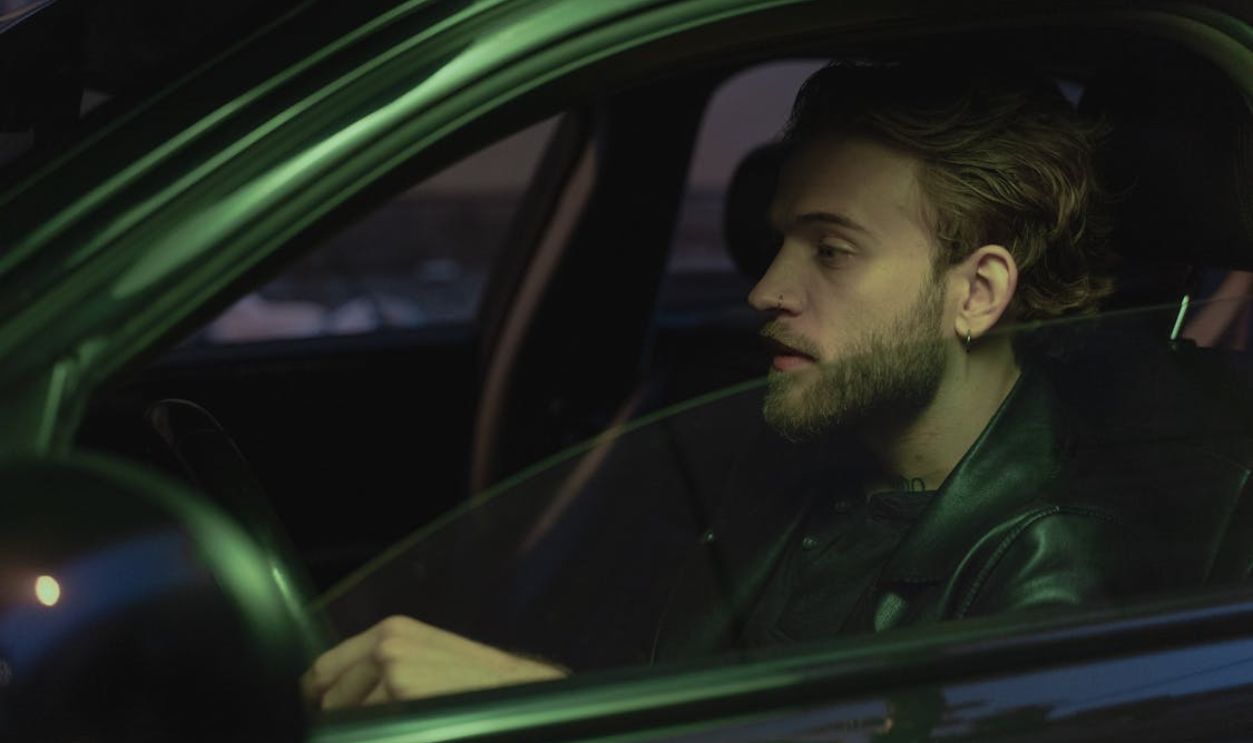 Man in Green Jacket Driving Car