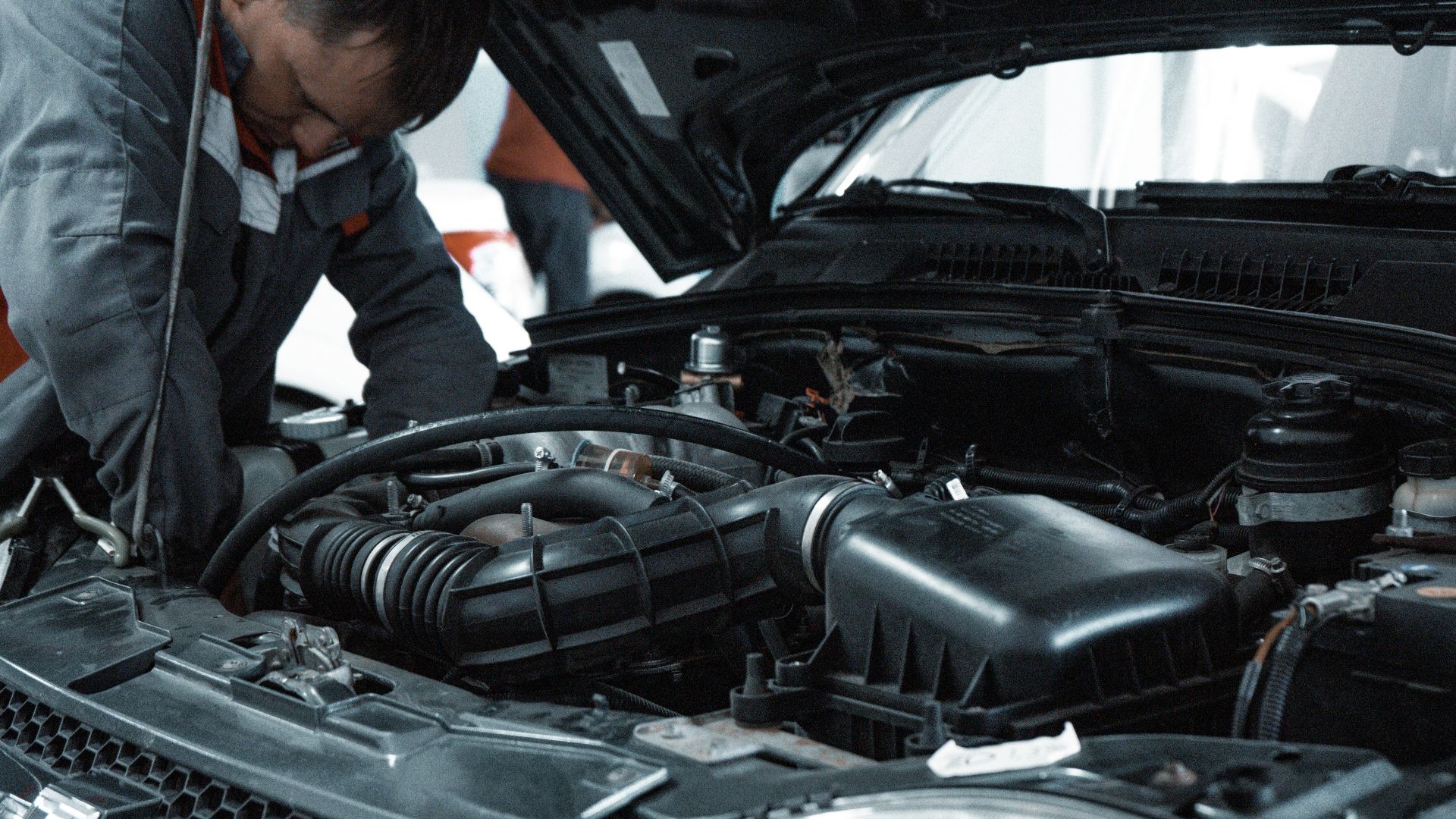 man in white shirt standing beside black car