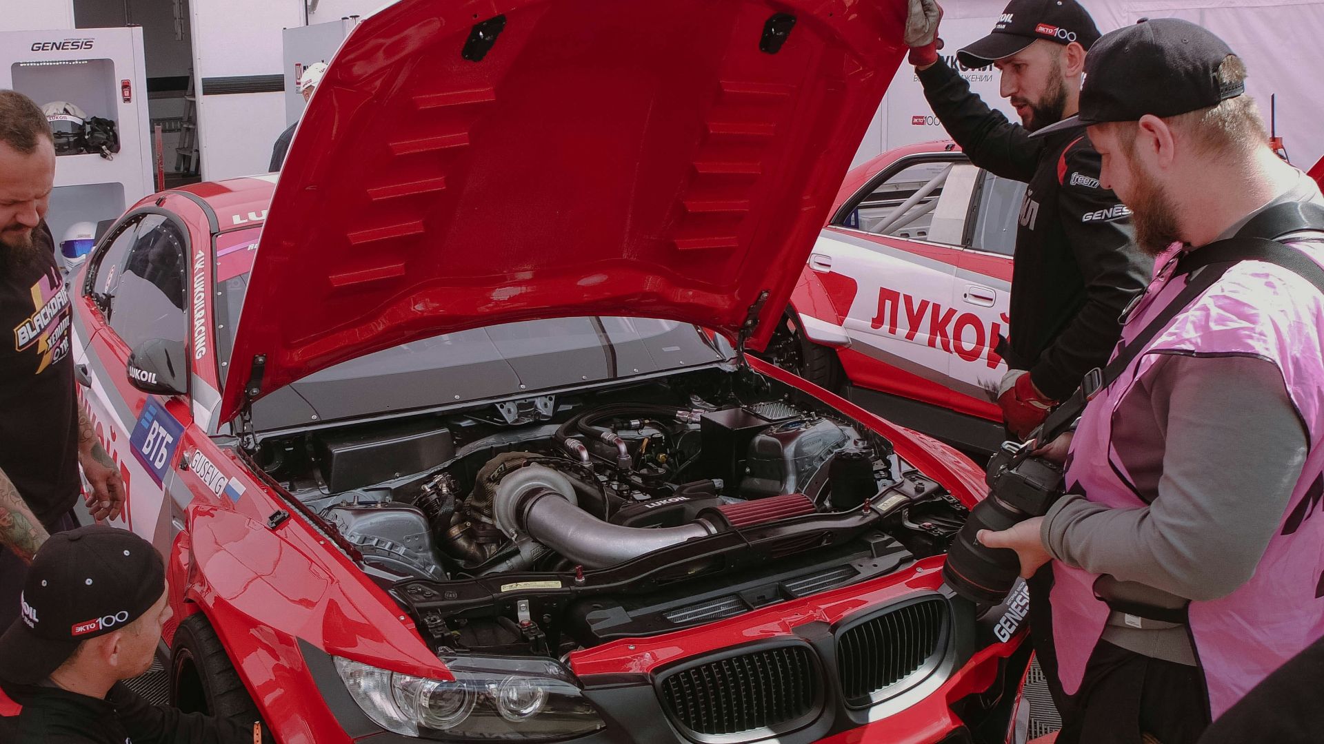 a group of men working on a red car