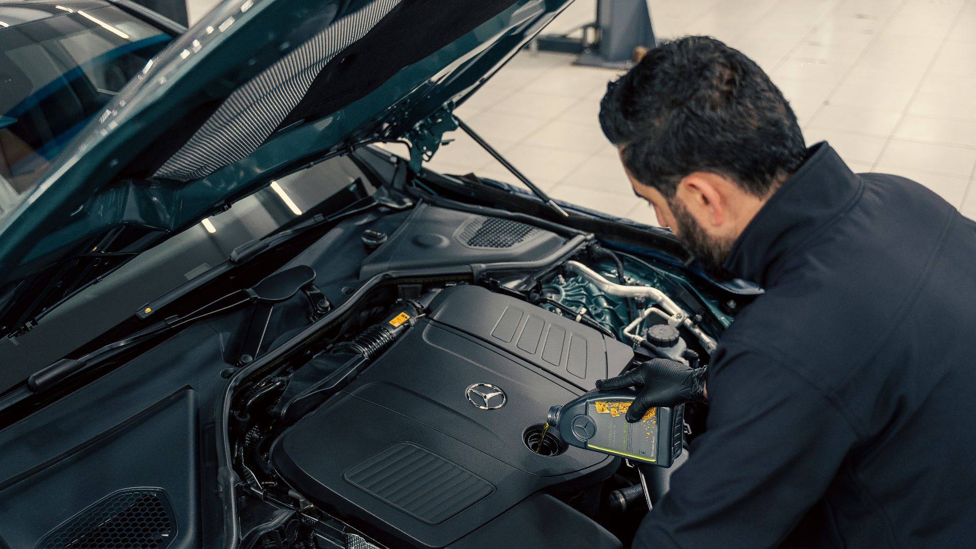Mechanic inspecting a car engine with hood open