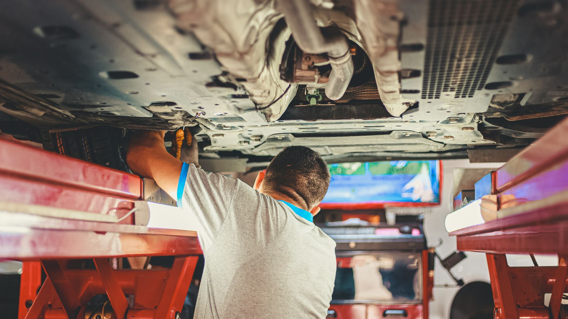 man in gray shirt sitting on red plastic chair