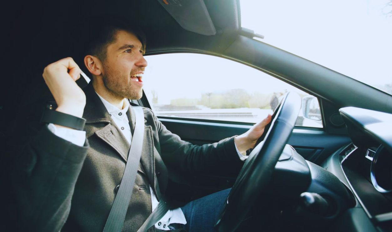 Happy Man Driving Car in Bright Daylight