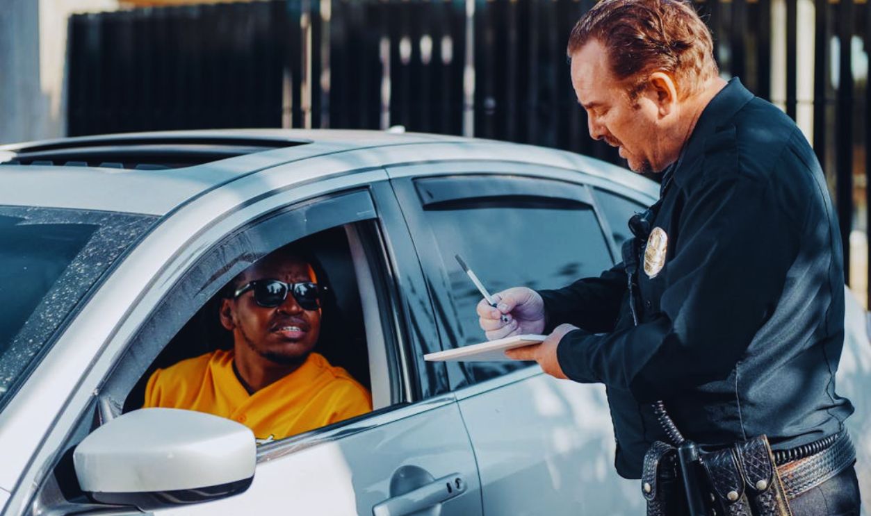 Man in Black Jacket Leaning on White Car