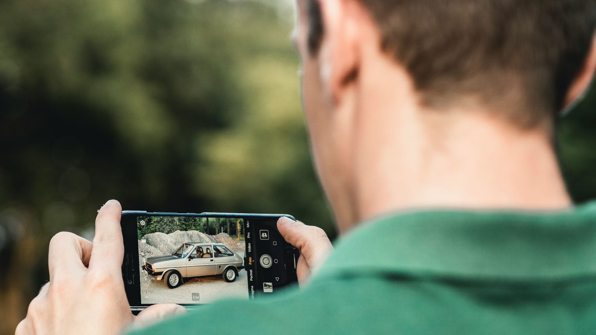 man taking photo of car