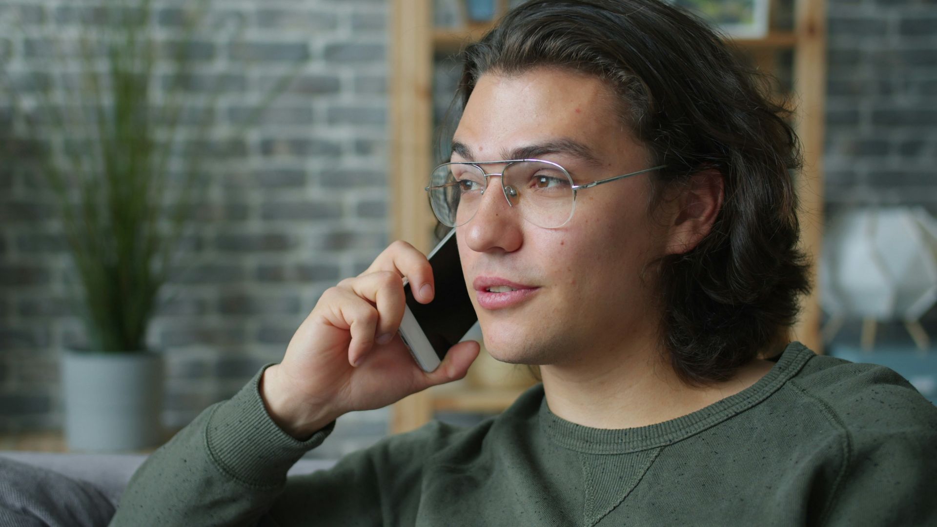Man wearing glasses talking on a smartphone.