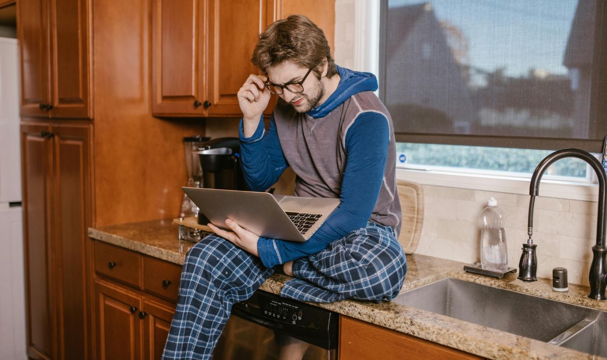 Man Seated on Counter Top near Kitchen Sink
