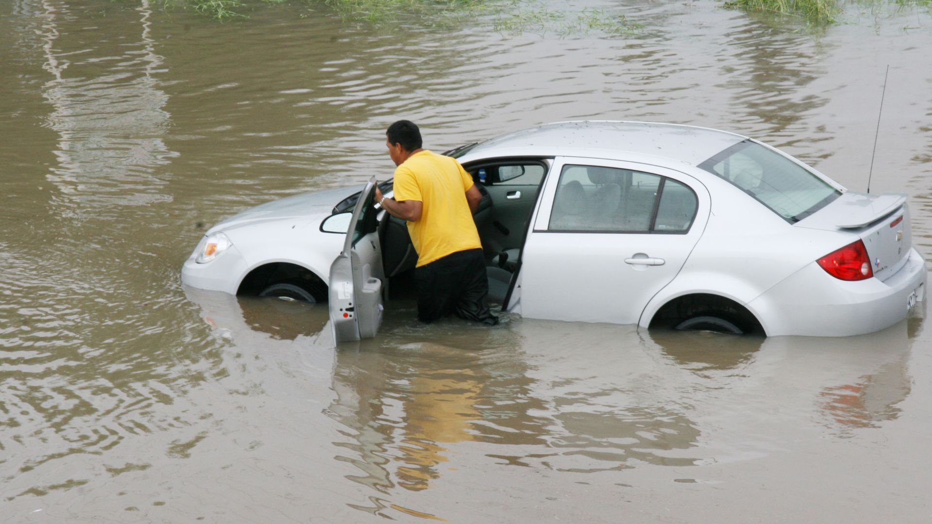 Brownsville, TX, July 24, 2008 -- A resident pushes his stalled car through a flooded street. Hurricane Dolly made landfall on South Padre island with 120 mph winds. Jacinta Quesada/FEMA