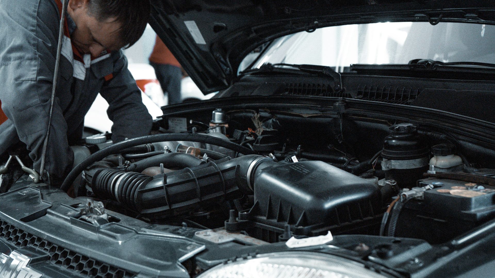 man in white shirt standing beside black car