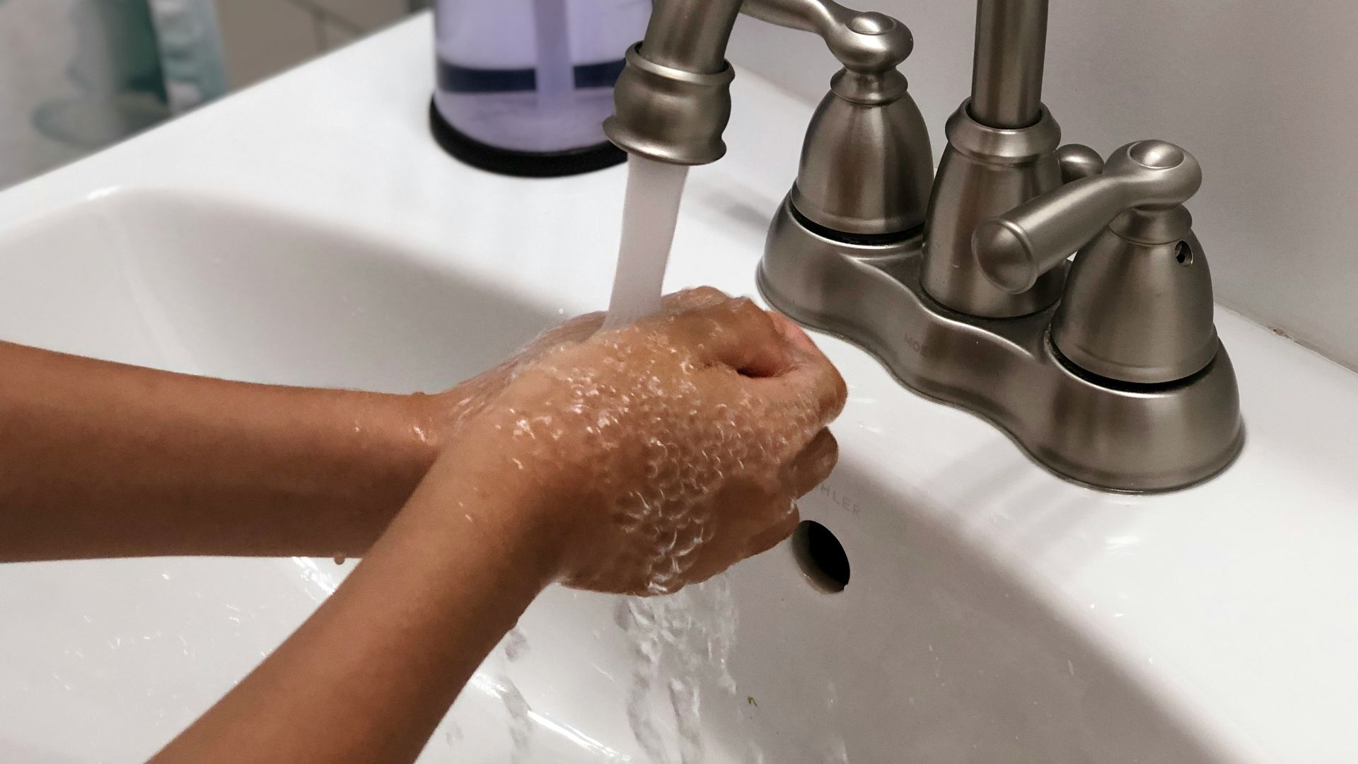 person washing hand on sink