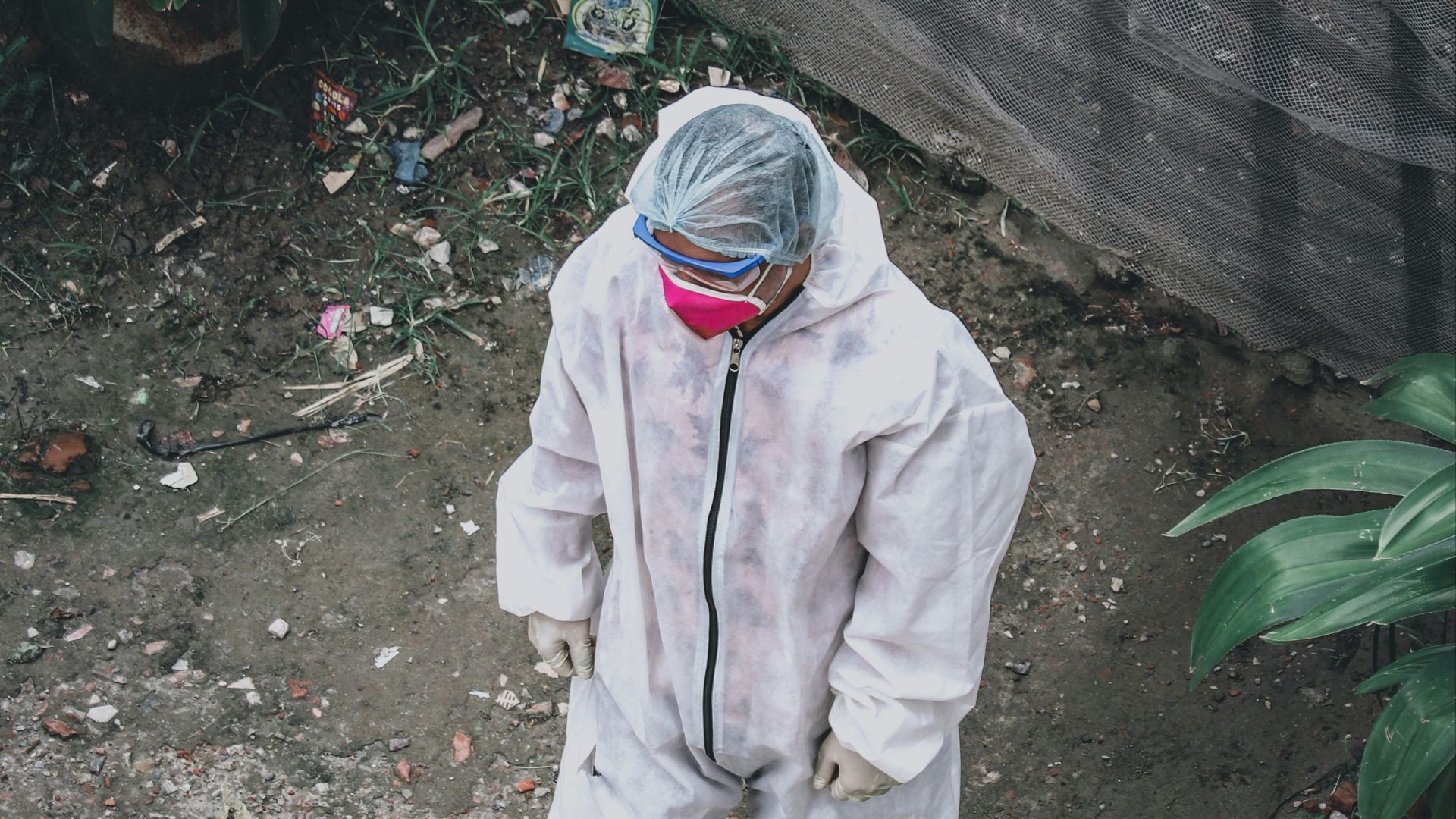 person in white jacket and pants standing near green plant during daytime