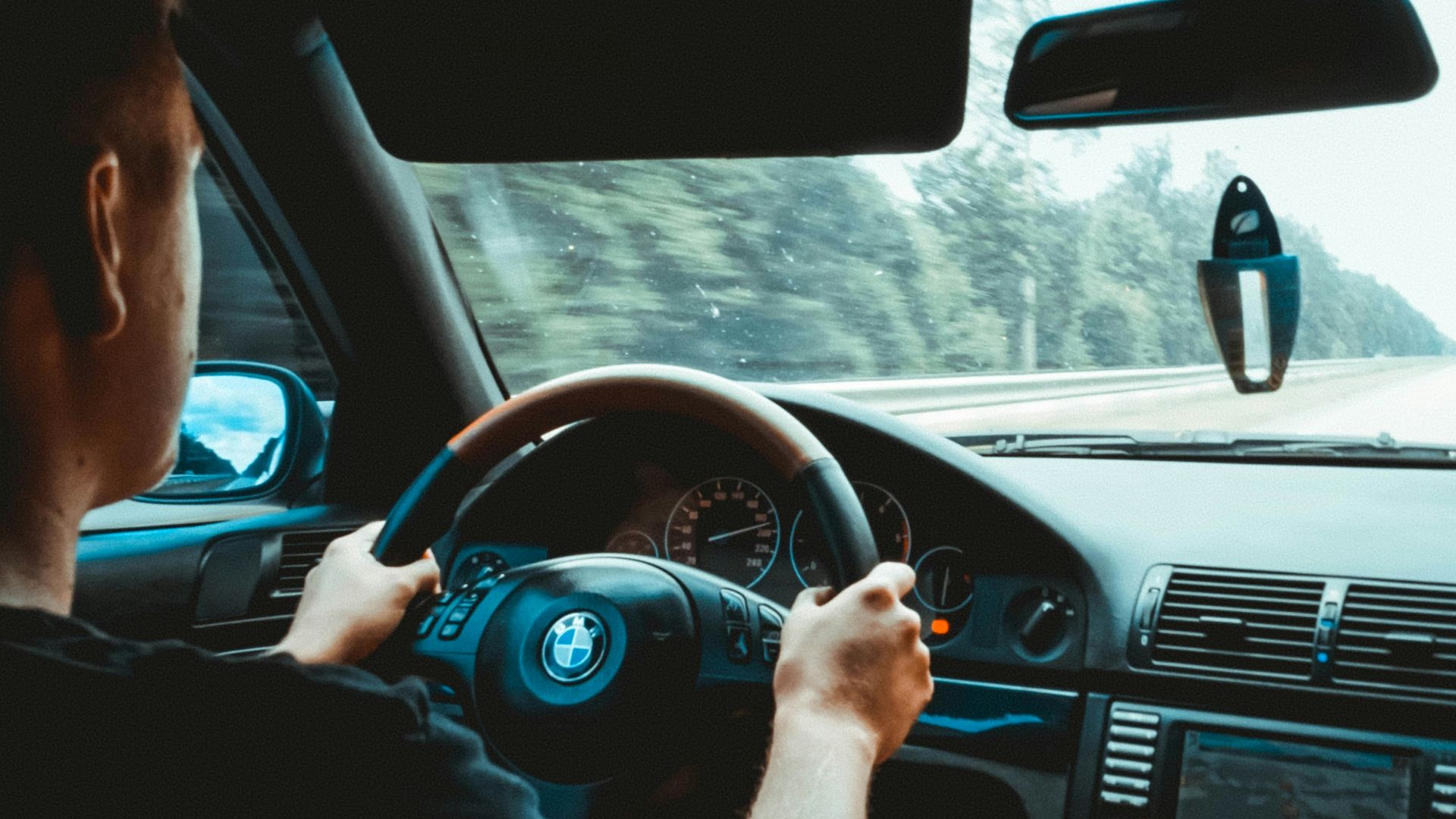 man in black tank top driving car