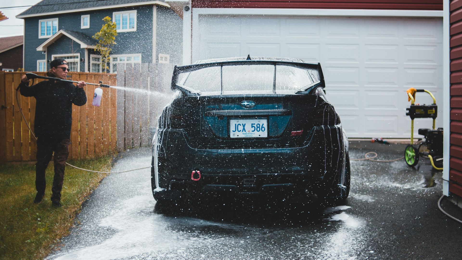 black bmw car parked beside red and white house