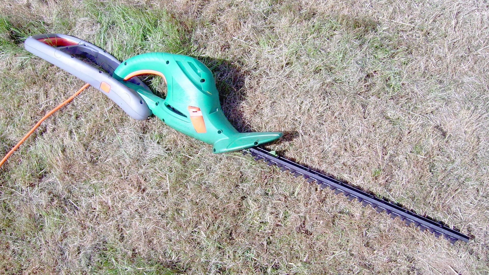 A large Black and Decker electric hedge trimmer, with extendable handle folded out.