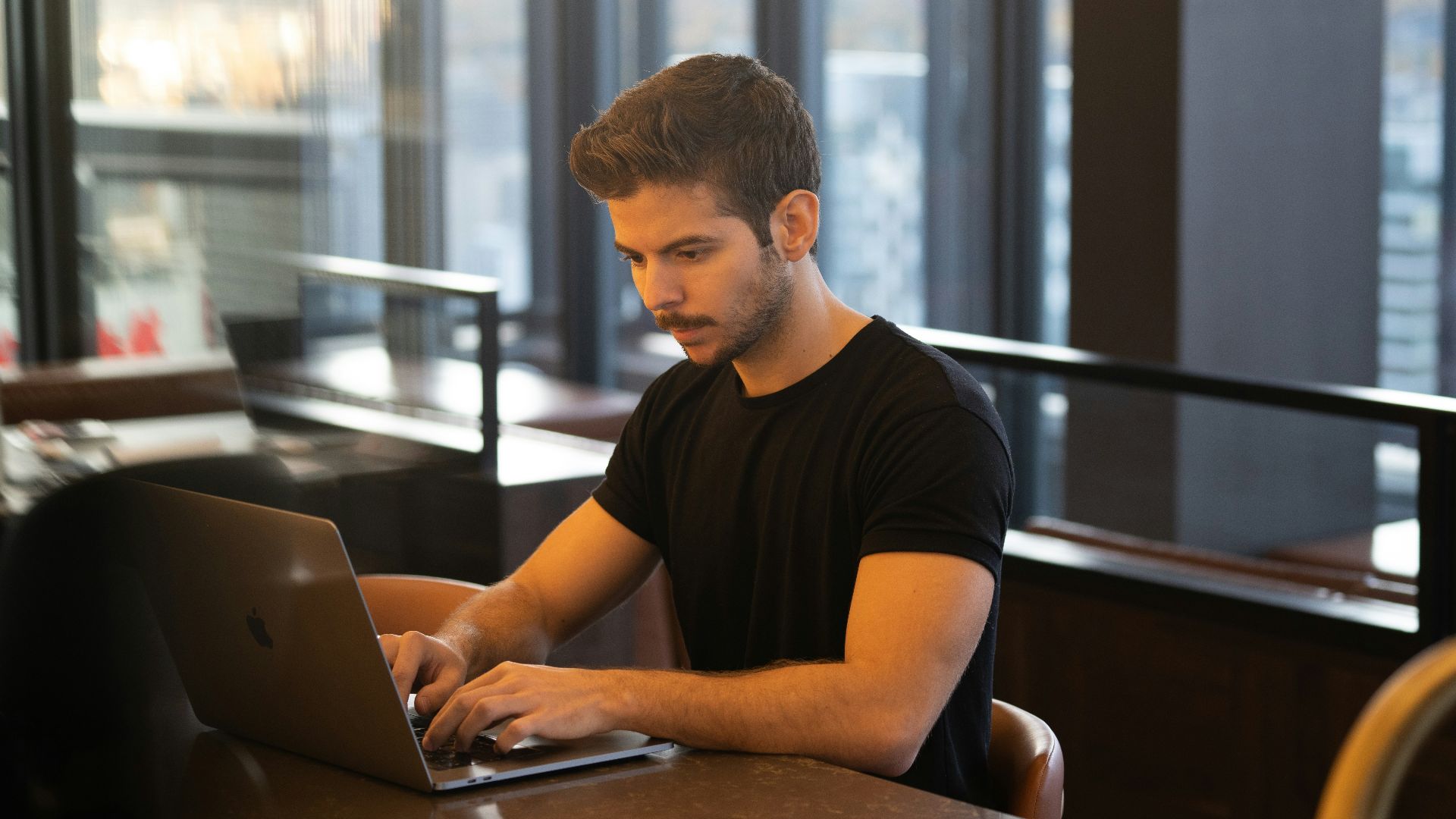 man in black crew neck t-shirt using macbook