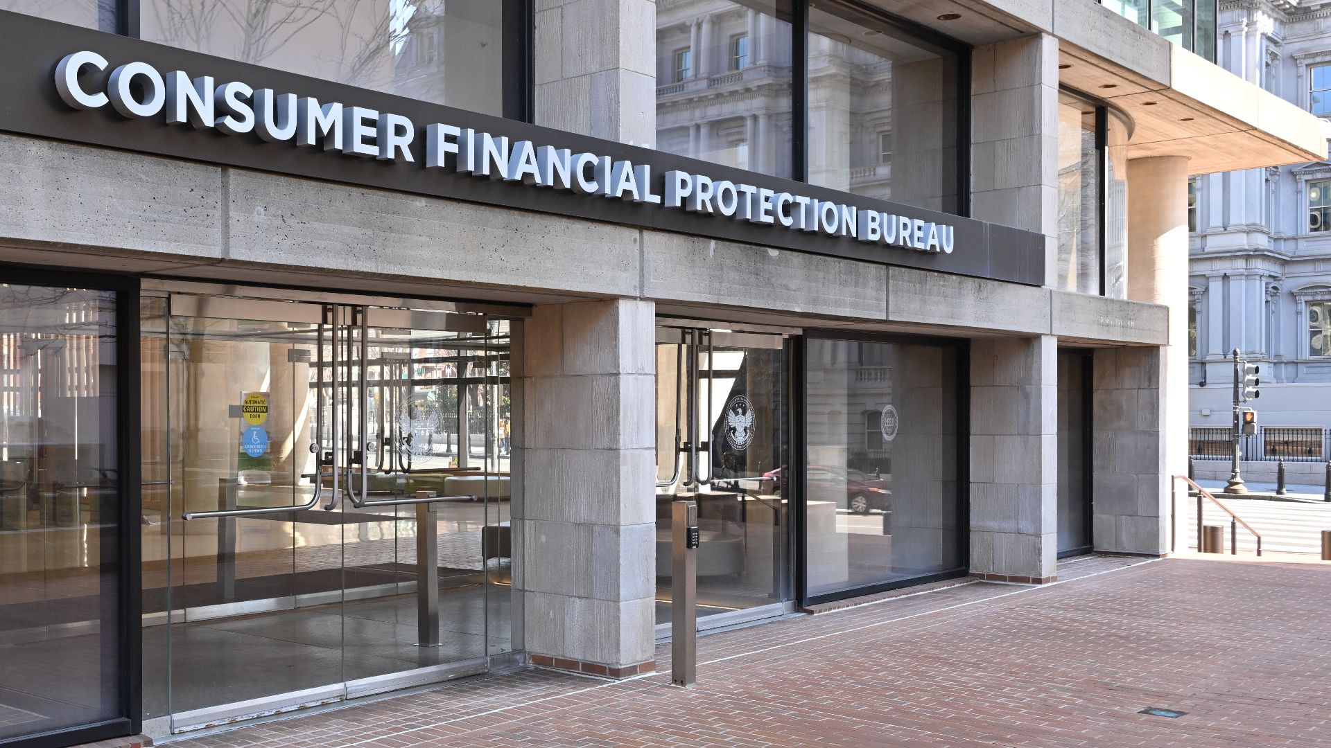 The entrance to the Consumer Financial Protection Bureau headquarters with the bureau's name above it. 1700 G Street NW, Washington, DC 20552.