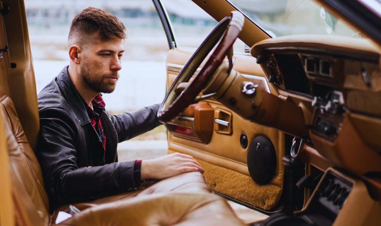 Male driver near vehicle with open door in street
