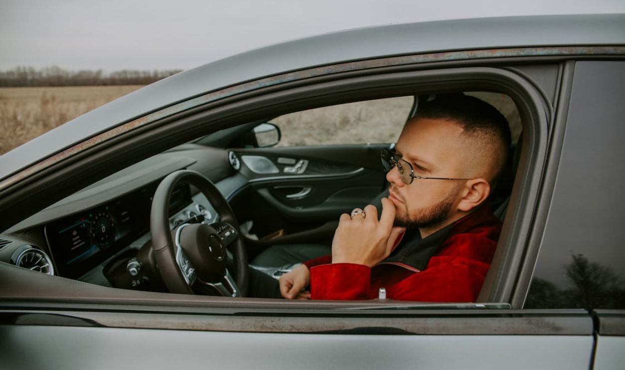 Stylish man sitting in front seat of car