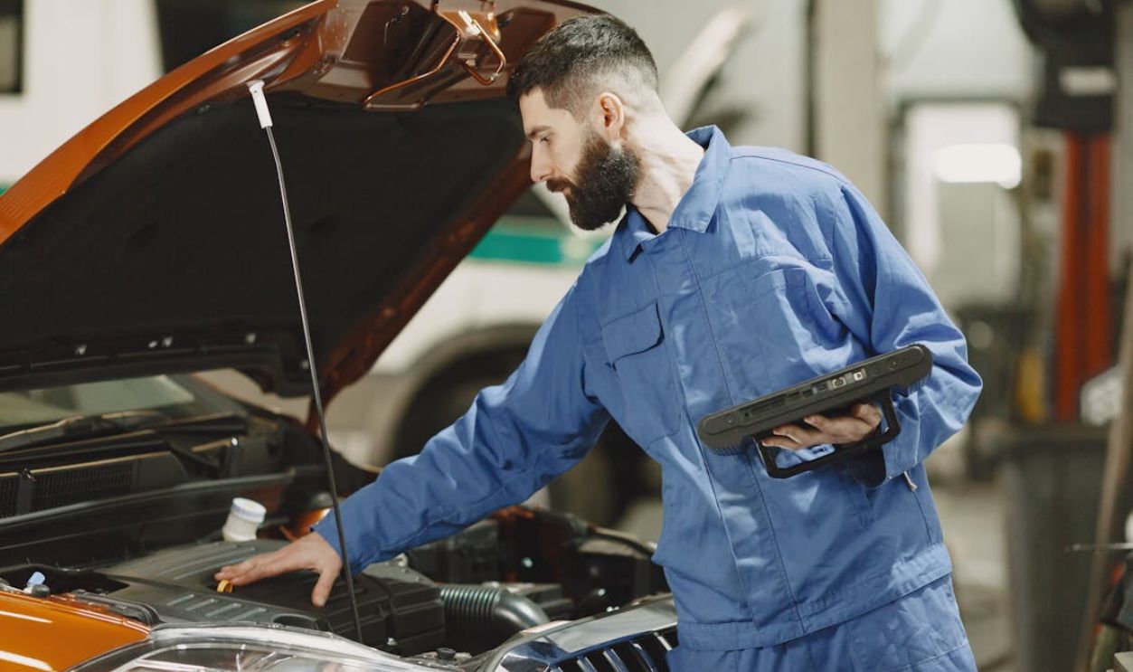 Mechanic Checking the Engine of a Car