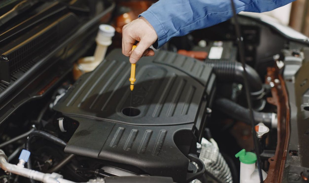 Person Checking the Oil of an Engine