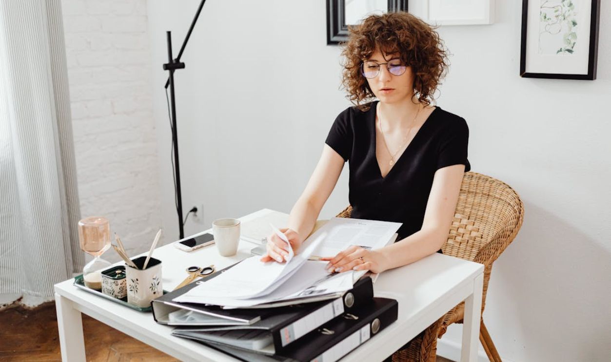 Woman Sitting by Table and Working