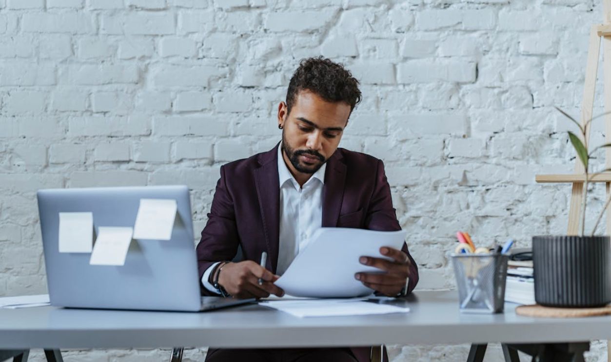 Man in Black Suit Looking the Document
