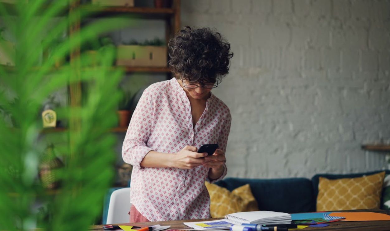 Young Woman Using Smartphone in Cozy Home Office