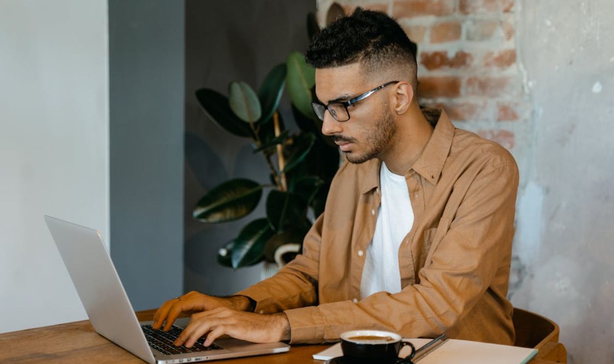 Man in Brown Dress Shirt Typing on a MacBook Pro