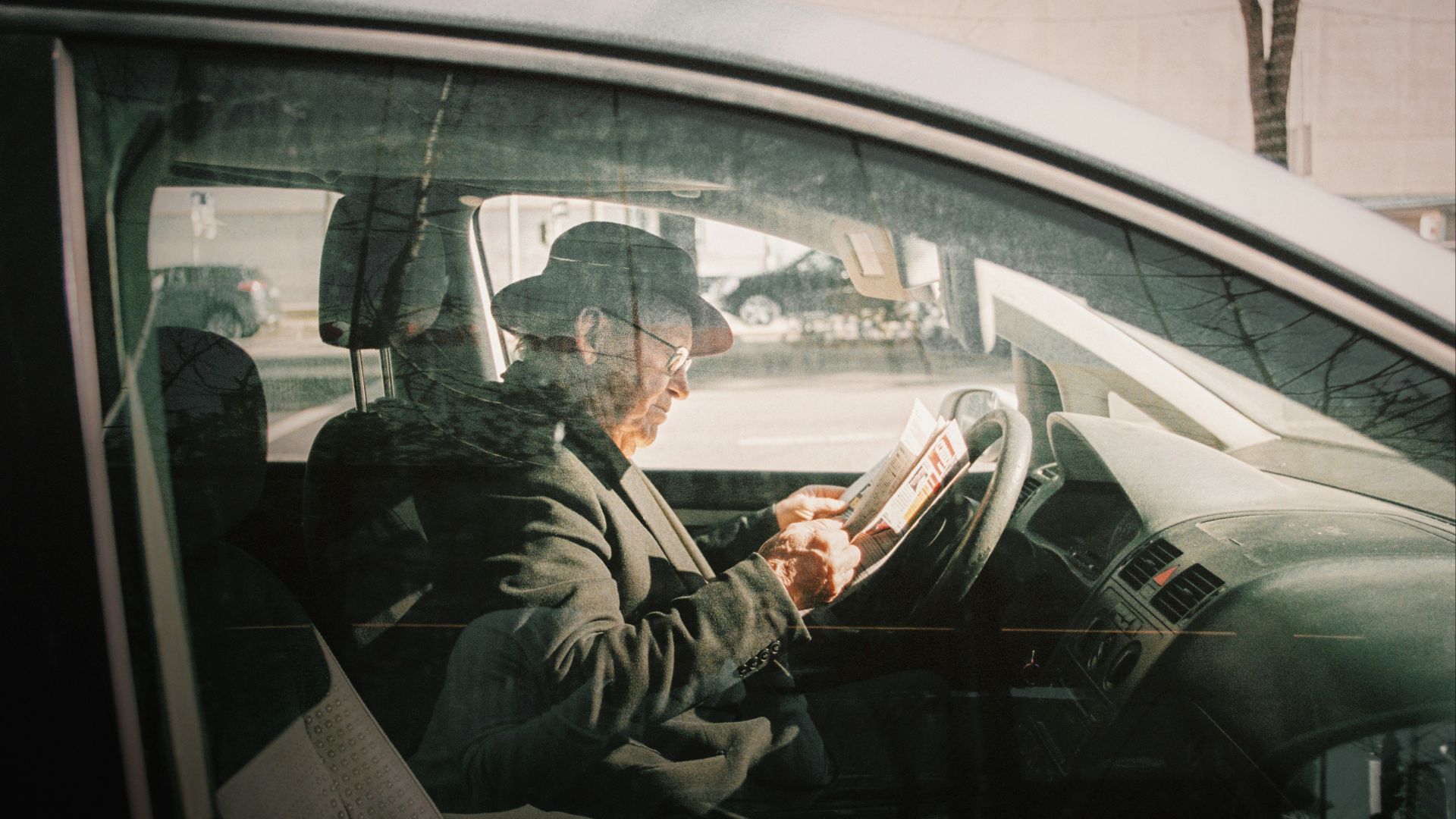 man in black jacket driving car